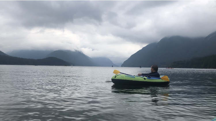 A man enjoying boating in the serene and beautiful mountain backdrop at Alouette River, Golden Ears Provincial Park, British Columbia