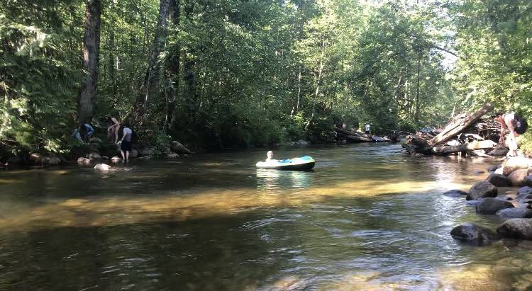 A man enjoying a ride in an inflatable boat at Coquitlam River, Lower Mainland, Vancouver during the summer heatwave in British Columbia